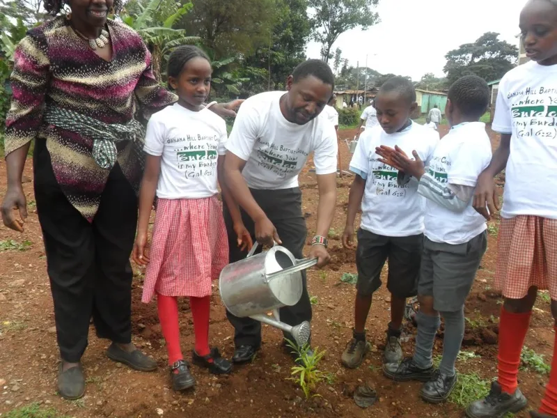 Pupils and community members planting a tree in Kenya